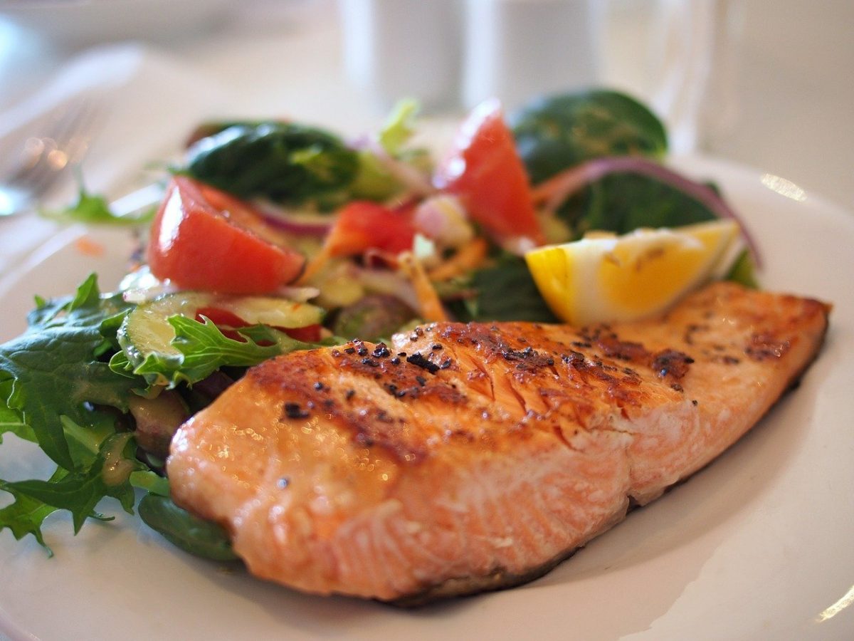 Salmon filet on a plate with a green salad