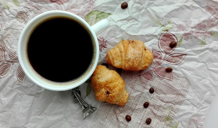 a cup of coffee and croissants have the maillard reaction on a white cloth