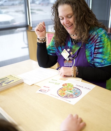 NTI graduate in a professional client session as a Nutritional Health Coach at Natural Grocers.