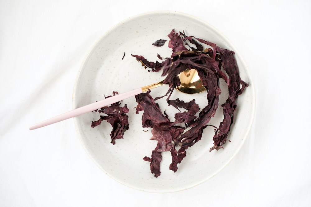 Sea vegetables served with chopsticks on a white plate