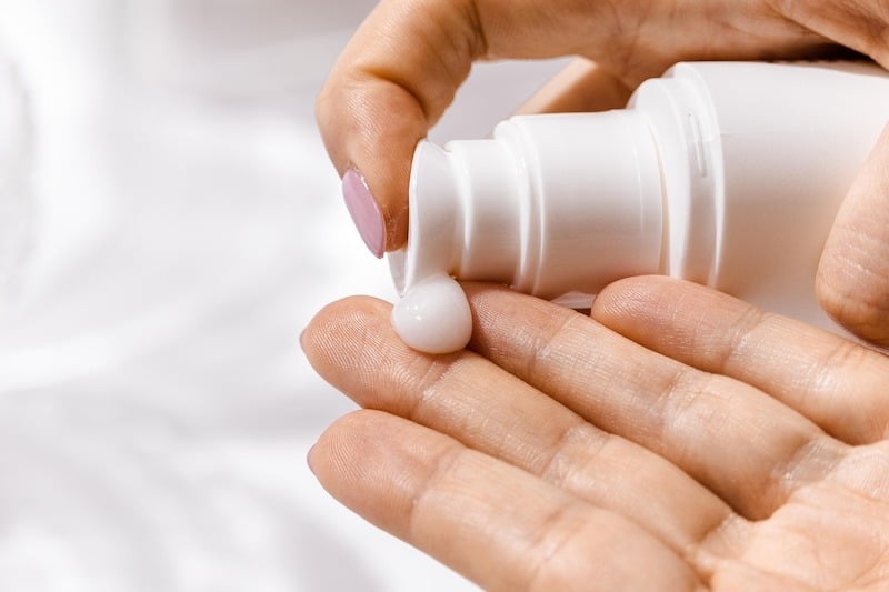 Hands applying cream to skin as an example of personal care product use