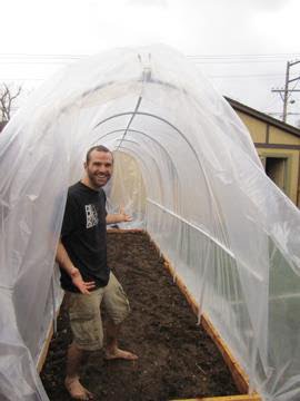 Geoff Brokx standing in his first green house