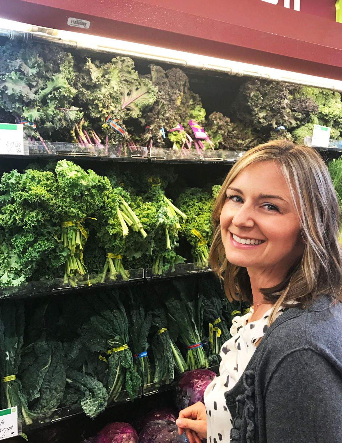 Megan Carpenter standing in front of green produce at the grocery store