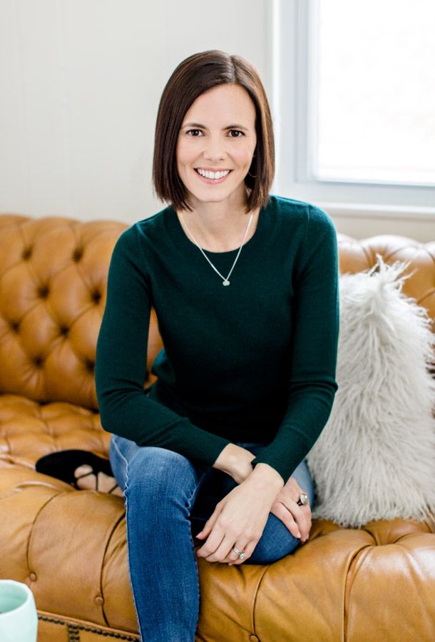 Liz Sanfilippo sitting on a brown leather couch in a black shirt and jeans